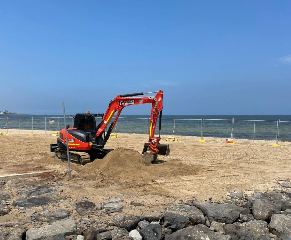 Excavator on landscaping job site moving earth